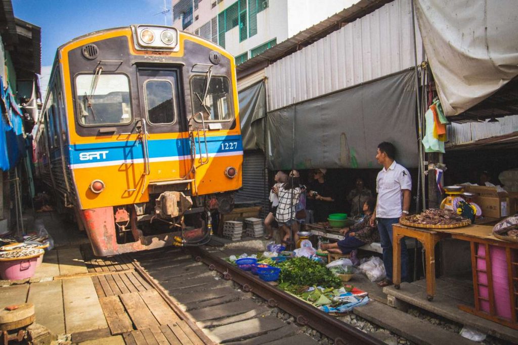 Train passing through the Maeklong Railway Market